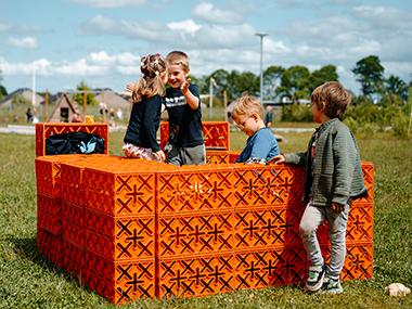 Børn der leger med byggekasser på legepladsen